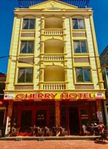 um edifício amarelo com um hotel alegre numa rua em Cherry Hotel em Sapa