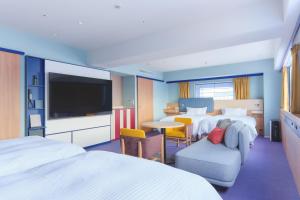 a hotel room with two beds and a flat screen tv at Miyako Hotel Kyoto Hachijo in Kyoto