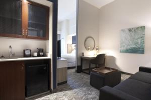 a room with a couch and a sink and a bed at SpringHill Suites Savannah Airport in Savannah