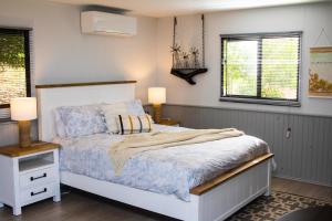 Lowden的住宿－Preston Valley Retreat，一间卧室配有一张床、两盏灯和两扇窗户。