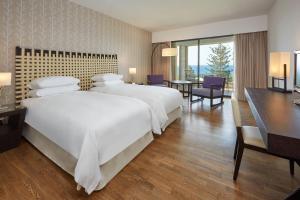 a large hotel room with two beds and a desk at Sheraton Rhodes Resort in Ixia