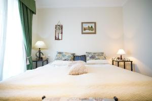 1 dormitorio con 1 cama blanca grande y 2 lámparas en Cozy Apartment in Puerto Banus, en Marbella