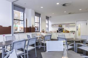 een restaurant met tafels en stoelen en een bar bij mk hotel london in Londen