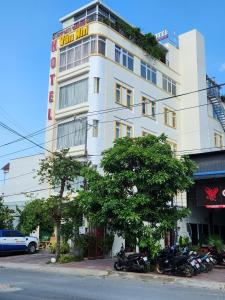 Biały budynek z motocyklami zaparkowanymi przed nim w obiekcie Khách sạn Vân Nhi w mieście Bạc Liêu