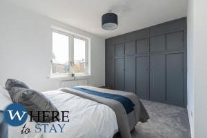 um quarto com uma cama e um armário cinzento em Apartment beyond forth Bridges - 3bed free parking em Inverkeithing