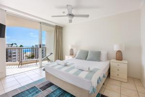 um quarto com uma cama grande e uma varanda em Rainbow Commodore Coolangatta em Gold Coast