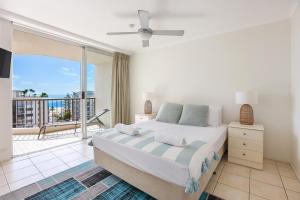 a bedroom with a large bed and a balcony at Rainbow Commodore Coolangatta in Gold Coast