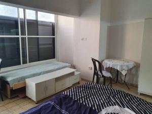 a bedroom with a bed and a table and a window at 2 bedroom apartment in batiya makov in Rechovot