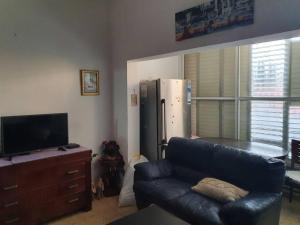 a living room with a couch and a refrigerator at 2 bedroom apartment in batiya makov in Rechovot