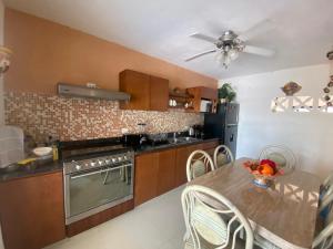 a kitchen with a table and a ceiling fan at Casa del artista in Mérida