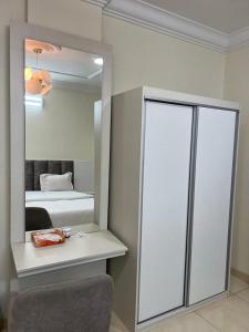 a bedroom with a mirror and a bed and a chair at بيوتي روز لشقق المخدومه in Abha
