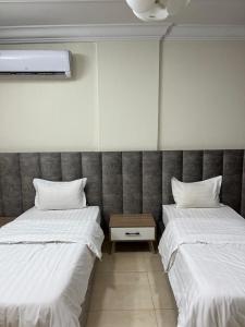 two beds sitting next to each other in a room at بيوتي روز لشقق المخدومه in Abha +3 photos