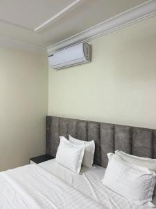 a bedroom with a bed with white sheets and pillows at بيوتي روز لشقق المخدومه in Abha