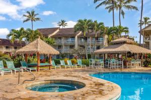 a resort with a swimming pool with chairs and umbrellas at Islander Ocean Resort Condo # 166 in Kapaa