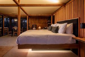a bedroom with a large bed and a dining room at The Enchanted Retreat - Unforgettable Luxury Glamping in Havelock North