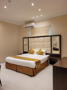 a bedroom with a large bed with yellow pillows at لاكازا للشقق المخدومة in Riyadh
