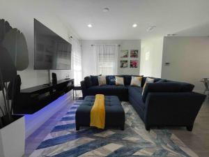 ein Wohnzimmer mit einem blauen Sofa und einem TV in der Unterkunft 3BD/2BTH Home Near Downtown Orlando in Orlando