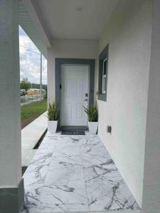 eine Eingangstür eines Hauses mit Marmorboden in der Unterkunft 3BD/2BTH Home Near Downtown Orlando in Orlando