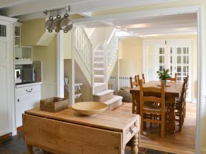 a kitchen and dining room with a table and a dining room at Wisteria Cottage in Alnham