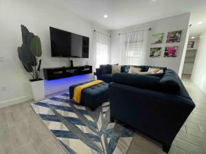un soggiorno con 2 divani blu e una TV di 3BD/2BTH Home Near Downtown Orlando a Orlando