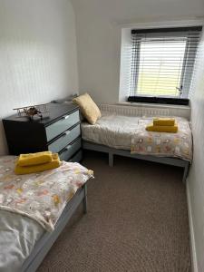 um quarto com 2 camas e uma cómoda e uma janela em Hare view Cottage - Northumberland 