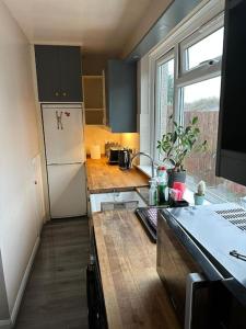 a kitchen with a white refrigerator and a window at Hare view Cottage - Northumberland 