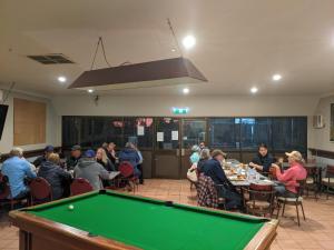 a group of people sitting at tables with a pool table at Kulgera Roadhouse in Kulgera