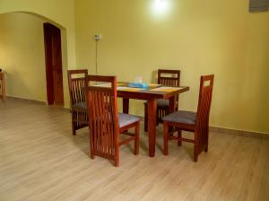 een eettafel met vier stoelen en een tafel met een stoel bij Ntebeko Homestay in Kisoro