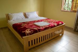 a large bed with a wooden frame in a bedroom at Ntebeko Homestay in Kisoro