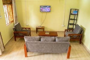 a living room with a couch and two chairs at Ntebeko Homestay in Kisoro