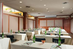 una sala da pranzo con tavoli bianchi e bottiglie verdi di Hotel dei Borgognoni a Roma