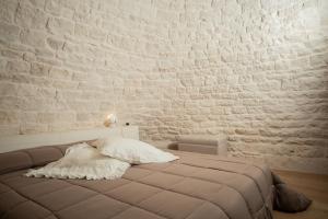 a bed in a room with a brick wall at Trullo Antica Bellezza in Alberobello
