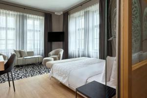 a hotel room with a bed and a desk at Le Méridien Vienna in Vienna