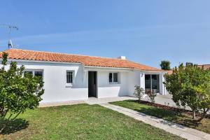 una casa bianca con il tetto rosso di Maison idéale pour un séjour aux Sables d'Olonne a La Pironnière