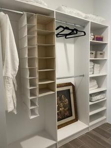a walk in closet with white shelves and towels at Narama Luxury near to the airport in Guatemala