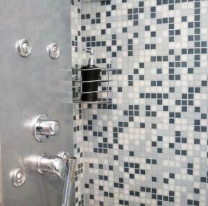 een douche met zwarte en witte tegels in de badkamer bij NinnAnna in Porto SantʼElpidio