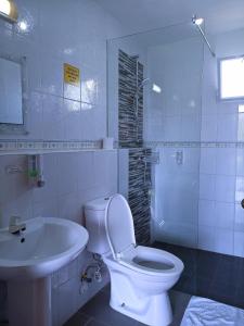Baño blanco con aseo y lavamanos en Alona42 Resort en Panglao