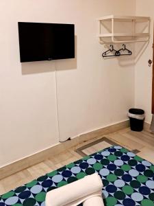 sala de estar con TV de pantalla plana en la pared en Arc House Plaza, en Sevilla