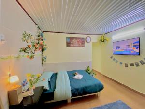 a bedroom with a bed with a blue blanket and a tv at Rose's House in Khu Chi Lăng +19 photos
