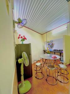 a room with a table and chairs and a kitchen at Rose's House in Khu Chi Lăng