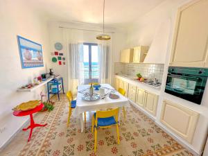 een keuken met een tafel en stoelen in een kamer bij La casa del pescatore in Sciacca