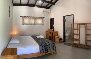 a bedroom with a bed and a bathroom at Balong Balong Surf Bungalows & Restaurant in Sekongkang