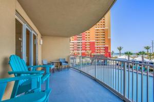 einen Balkon mit Stühlen, einem Tisch und einem Gebäude in der Unterkunft Calypso 3-205 in Panama City Beach