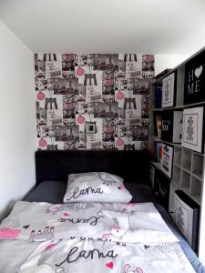 um quarto com uma cama com uma parede coberta de fotografias em Gemini Vendégház em Harkány