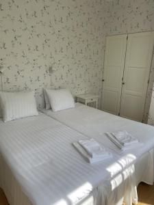 a bedroom with a white bed with towels on it at Pensionat Haga Öland in Löttorp