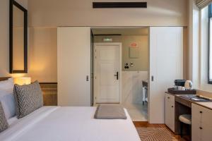 a bedroom with a large white bed and a bathroom at Casa da Marechal - Boutique Hotel by Oporto Collection - Adults Only in Porto
