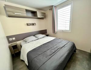 Un dormitorio con una cama grande y una ventana en Camping Des Mimosas, en Argelès-sur-Mer