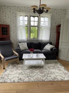 a living room with a couch and a coffee table at Pensionat Haga Öland in Löttorp