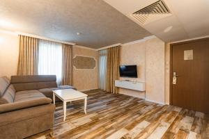 sala de estar con sofá y TV en Hotel Baikal - All Inclusive, en Sunny Beach