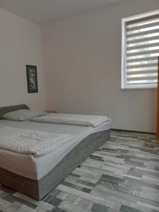 a bedroom with a bed in a room with a window at Apartman Laguna in Balatonlelle